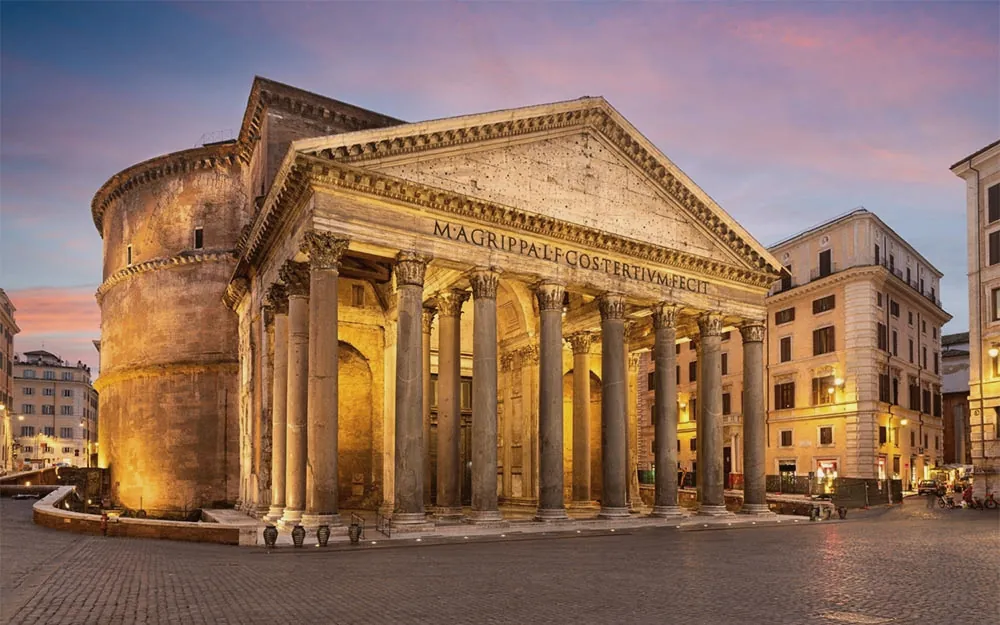 A fachada do Panteão de Roma ao entardecer, com as colunas iluminadas.